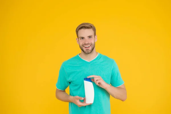 Asistente de tienda amigable. hombre feliz celebrar botella de champú. tipo lavando el cabello con mousse. peluquería y peluquería. publicidad de gel hidratante médico. terapia de baño perfecta — Foto de Stock