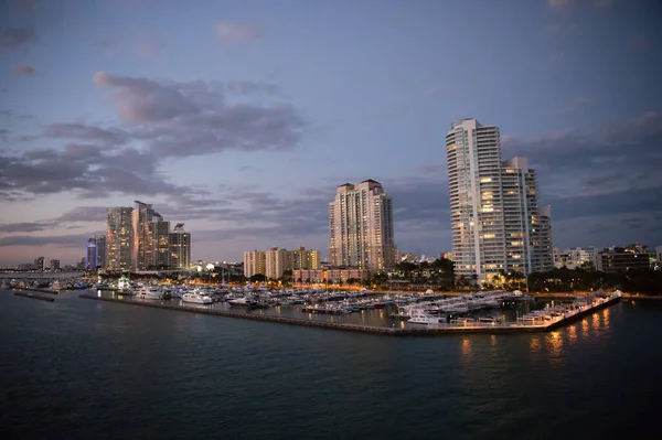 Urban paradise. City skyline. City and yacht club from sea. City architecture at dusk. Twilight of city. Illuminating lights on cloudy evening sky. Travelling and wanderlust. Travel destination — Stock Photo, Image