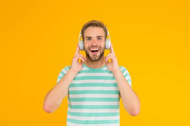 İşte ben buna müzik derim. Mutlu adam sarı arka planda müzik dinliyor. Yakışıklı adam kulaklıkla müzik çalmaktan hoşlanıyor. Modern hayat. Yeni teknoloji. Eğlence ve eğlence. Müzikte kaybolmuş