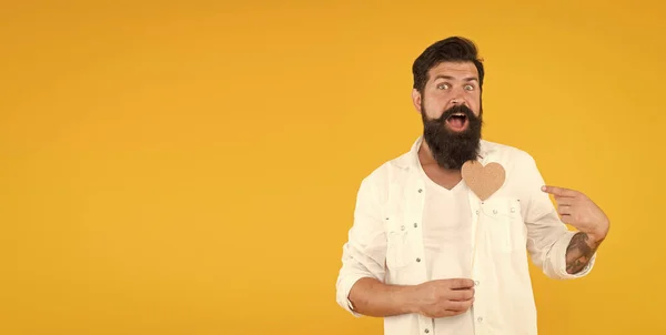 Homem com barba e bigode fundo amarelo. Coração feito à mão para férias. espaço de cópia. Coração brutal hipster dos namorados. Festa dos namorados. Homem barbudo pronto para o encontro amoroso. Saudação romântica — Fotografia de Stock