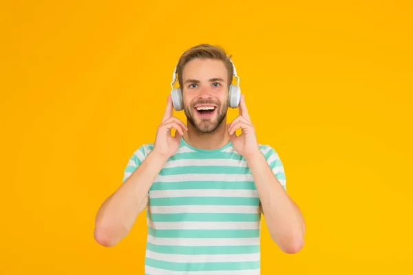 C'est ce que j'appelle de la musique. Happy guy écouter de la musique fond jaune. Un bel homme aime jouer de la musique dans les écouteurs. La vie moderne. Nouvelle technologie. Amusement et divertissement. Perdu dans la musique — Photo