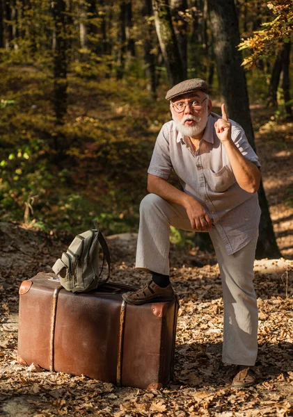 Semester och koppla av. Pensionskoncept. Farfar med vintage resväska i naturen. Förenat med naturen. Helg i naturen. Gammal man med vitt skägg i skogen. Hobby och fritid. Äldre personer — Stockfoto