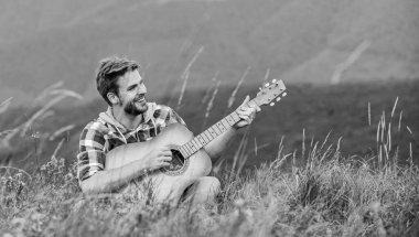 Kalbinde bir şarkı tut. Kareli gömlekli, gitarlı seksi bir adam. Hipster modası. Batı kampı ve yürüyüş. Mutlu ve özgür. Akustik gitaristli kovboy adam. country müzik şarkısı