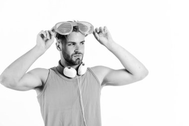 Yaz müzik çizelgesi. Yaz müziğini dinleyen tıraşsız bir adam. Parti konsepti. DJ çocuk. Popüler yaz şarkıları listesi. Teknoloji ve eğlence. Modern hayat. Kulaklık ve güneş gözlüklü yakışıklı adam.