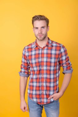 Öğrenci hayatı. Yaz ve bahar erkek koleksiyonu. Sarı arka planda kareli gömlekli yakışıklı bir adam. Seksi ve kendinden emin. Oğlan gündelik tarzda. Havalı saç stili olan berber. Gömlekli manken.