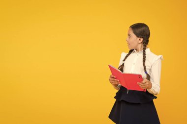 Dil eğitimi. Evde çalış. Ders kitabı ile sevimli çocuk çalışması. Okul çalışmaları için okuma becerilerini pratik edin ve geliştirin. Okul konseptine geri dönelim. Kız kitap tutun. Sarı arka planda okul kız