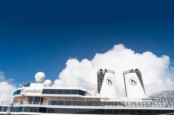 Miami, USA - December 31, 2015: upper decks and twin funnels of Eurodam. Facade of cruise ship on cloudy blue sky. Rows of cabin windows and balconies. Maritime transport. Adventure and discovery — Stock Photo, Image