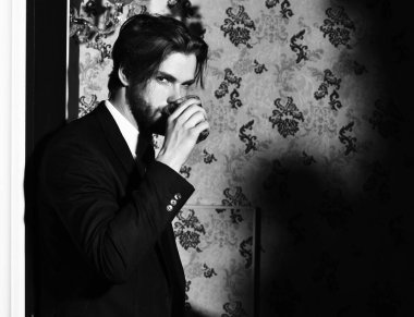 Sakallı adam, takım elbiseli iş adamı, kırmızı kravat viski bardağı tutuyor.