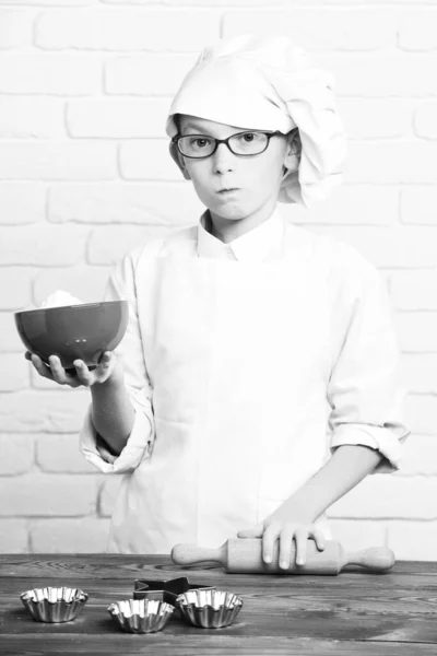 Сердитый мальчик милый повар повар на фоне кирпичной стены — стоковое фото