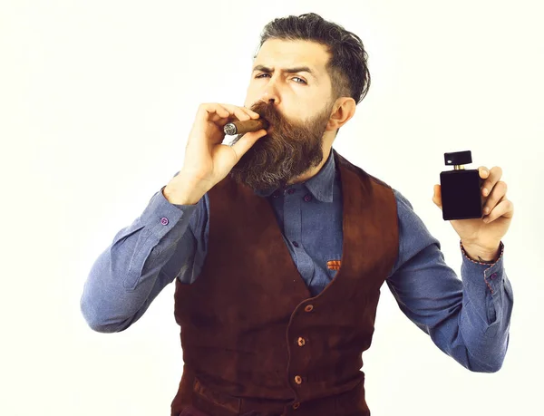 Homme barbu fumant cigare avec un visage sérieux, tenant parfum — Photo