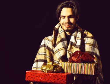 Siyah stüdyo geçmişinde ekoseli sakallı, gülümseyen bir adam.