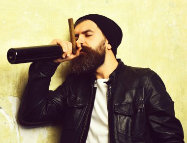 Sakallı, Kafkas hippisi elinde şişe, puro içiyor.