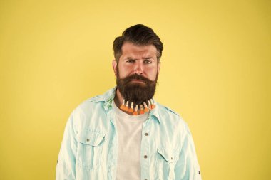 Havalı ve şık. Kalpli acımasız bir hippi. Sakallı adam sıradan sarı arka plan. Sevgililer Günü. Kuaförde saç kurutma. Bireysel erkek saç stili. Adam sakallı mandal