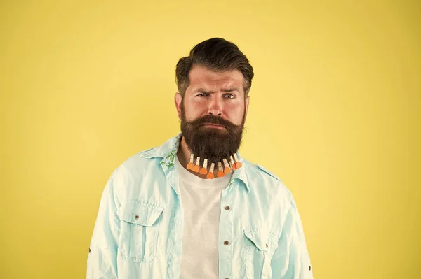 Hip und stylisch. Brutaler Hipster mit Wäscheklammern-Herzen. bärtiger Mann lässigen Stil gelb Hintergrund. Valentinstag. Haartrocknen im Friseur. individuelle Frisur für Männer. Mann Wäscheklammer am Bart — Stockfoto