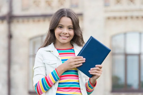 Η έξυπνη βιβλιοθήκη είναι ανοιχτή. Ευτυχισμένο παιδί κρατήσει βιβλίο βιβλιοθήκη σε εξωτερικούς χώρους. Το κοριτσάκι πάει στη βιβλιοθήκη. Σχολική βιβλιοθήκη. Σπουδάζει λογοτεχνία και γλώσσα. Ημέρα γνώσης. Βιβλιοπώλη. Βιβλιοπωλείο. Εκπαίδευση και σπουδές — Φωτογραφία Αρχείου