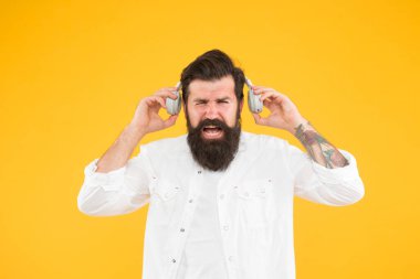 Ses tonuna katlanamıyorum. Yaz hit şarkılar listesi. Acıdan kıvranan vahşi hippi. En sevdiği şarkı. Sarı arka planda manken. Kulaklık takmış olgun bir DJ. Müziği dinle. Sakallı adam kulaklık takıyor.