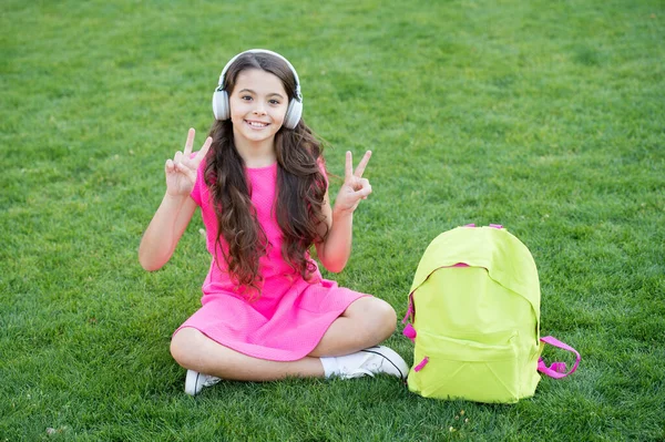 Fácil de ouvir e estudar. Menina feliz gosta de ouvir música. A criança pequena pratica habilidades de escuta. A ouvir o curso. Ensino à distância. Escola e educação. Vida moderna. Em ondas pacíficas — Fotografia de Stock