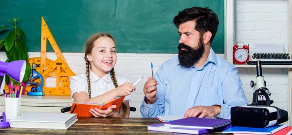 Interesante libro para niños. estudio de la hija con padre. Día del maestro. Día del conocimiento. Enseñanza en casa. de vuelta a la escuela. educación desarrollo infantil. barbudo hombre profesor con pequeña chica en el aula —  Fotos de Stock