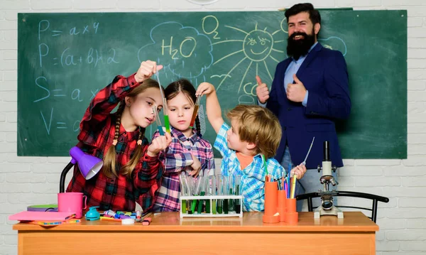 Niños con bata de laboratorio aprendiendo química en el laboratorio escolar. laboratorio de química. feliz maestro de niños. de vuelta a la escuela. haciendo experimentos en laboratorio o gabinete químico. lluvia de ideas — Foto de Stock