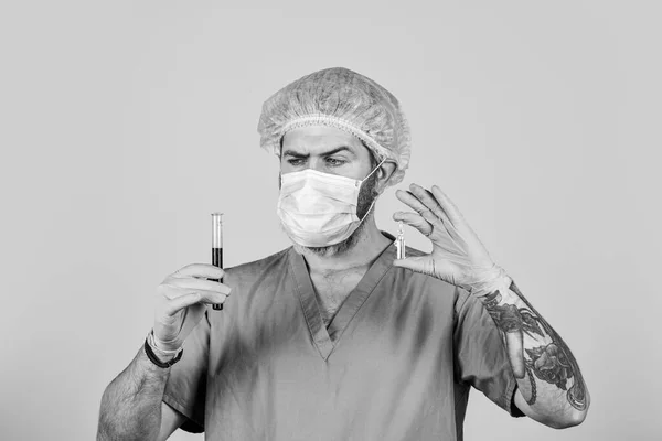 Tıp bilimadamları test tüplerini tutuyor. Test sırasında cerrahi maske takan bir doktor. Hemşire laboratuvarda kan örneklerini inceliyor. Coronavirus nedir? Yeni virüs gribine karşı ilaç. salgın — Stok fotoğraf