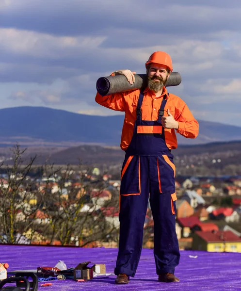 Techo de reparación Roofer. Instalación de techo. Hombre duro sombrero de trabajo paisaje al aire libre fondo. Construyendo casa. Aplicar recubrimientos plásticos membranas de fibra de vidrio o fieltro sobre techos inclinados antes de aplicar tejas — Foto de Stock