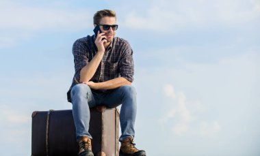 Seyahat etmeyi kabul et. Gözlüklü iş adamı. İş gezisi. Maço turist rahat tur çantası. Erkek modası. Çok modaya uygun görünüyorsun. Seksi adam gökyüzü arka planı telefonda konuşuyor. Gezgin, taksi bekle. Taşı