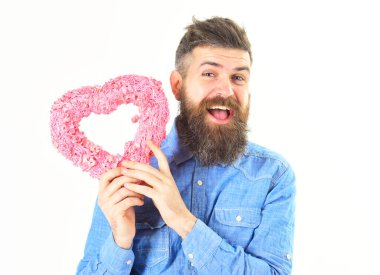 Bıyıklı adam pembe kalbi beyaz arka planda tutuyor..