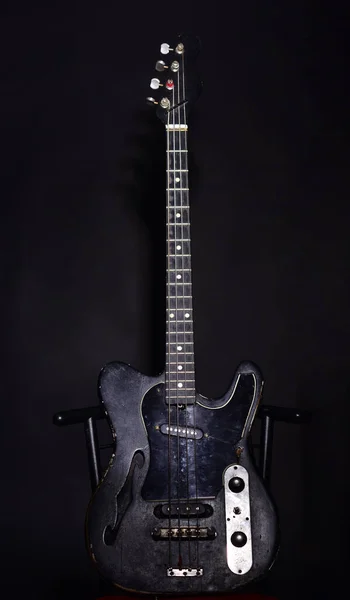 Guitar in deep black color on black background.