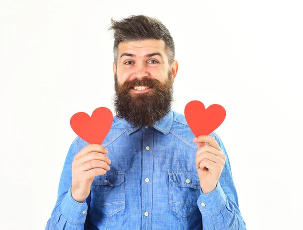 Человек с бородой со счастливым лицом держит красные бумажные сердца — стоковое фото