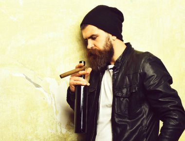 Sakallı, Kafkas hippisi elinde şişe, puro içiyor.