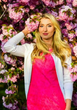 Kadınlık. Sakura mevsimi. Sakura ağacı çiçek açıyor. Pembe mod. Bahar moda koleksiyonu. Kadın bahar çiçeği sakura çiçek açar. Bahçedeki sarışın kadın. Harika bir kız. Kiraz çiçeği kızı.