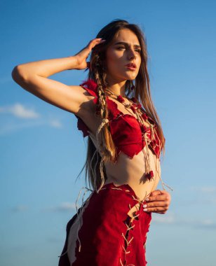 Lezzetli bir kız. Vahşi kadın gün batımına bakar. Bağımsız stil güzellik. Kadının şık saçları var. Güzellik ve moda. Vahşi çekici kadın. Gün doğumunda boho tarzı kıyafetlerle poz veren manken.