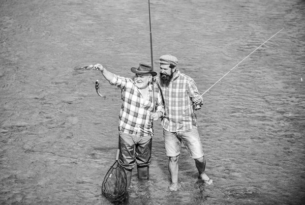 Travailler ensemble est un succès. pêcheur avec canne à pêche et filet. hobby et activité sportive. Un appât à truites. week-end d'été. homme mûr pêcheur. pêche père et fils. amitié masculine. liens familiaux — Photo