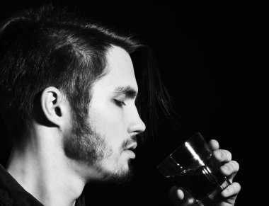 Stüdyoda viski içen ciddi sakallı bir adam.