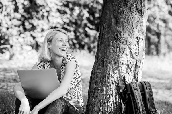 Kvinnlig student sitter på gräs medan han studerar. Jobba i sommarparken. Naturen nödvändig välfärd och förmåga vara produktiv. Flicka arbeta med bärbar dator i parken. Skäl till varför du bör ta ditt arbete utanför — Stockfoto