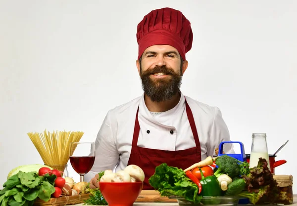 Laga mat med glada ansikte i uniform sitter vid köksbordet — Stockfoto