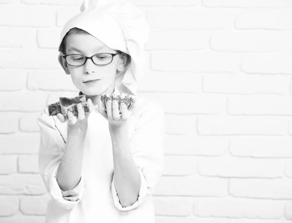 Stained cute cook chef boy on brick wall background, copy space — Stock Photo, Image