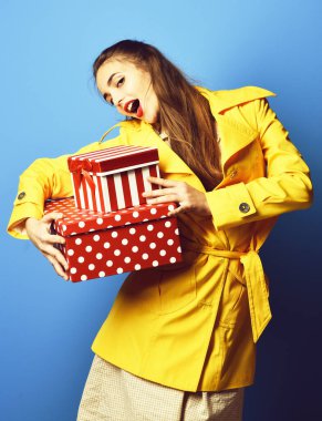 Mavi stüdyo arka planında askısı olan gülümseyen renkli kız.