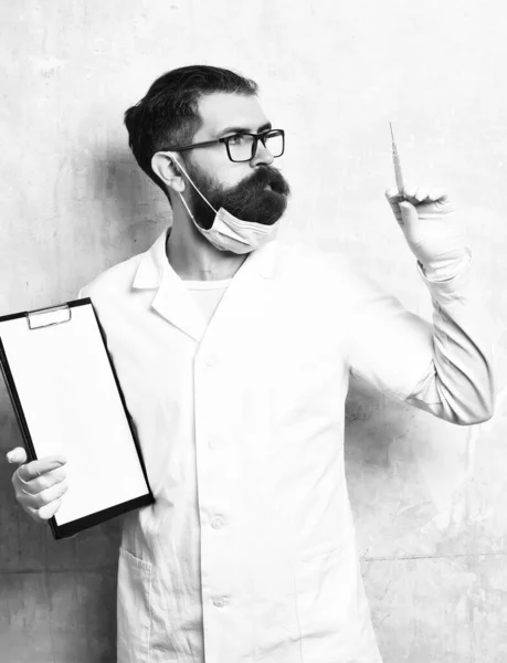 Bearded brutal caucasian doctor or postgraduate student holding clipboard — Stock Photo, Image