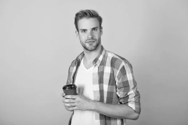 Café fraîchement infusé. Un beau mec boit du café fond jaune. Un jeune homme tient une tasse de café à emporter. Boisson énergétique. Le matin et le petit déjeuner. Bonjour commence par le café — Photo