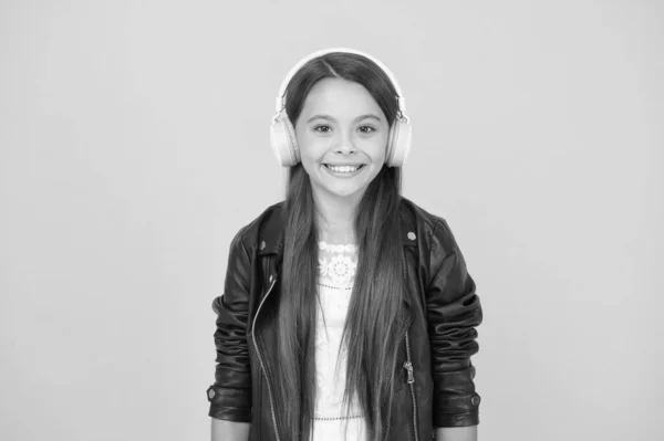 Sonrisa feliz. hipster chica de estilo urbano. concepto estilo de vida. Niño motociclista con auriculares. niña pequeña en chaqueta de cuero. estilo de moda de otoño. niño escuchar música rock. pequeña escuela de radio dj. lady DJ pelo largo — Foto de Stock