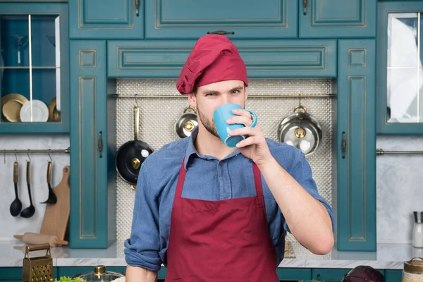 Homem chef beber chá. Um homem bonito está segurando uma xícara. barista qualificado e profissional. o homem trabalha no bar ou restaurante do café. Proprietário de pequenas empresas. masculino cozinheiro em cozinha desgaste pessoal uniforme — Fotografia de Stock