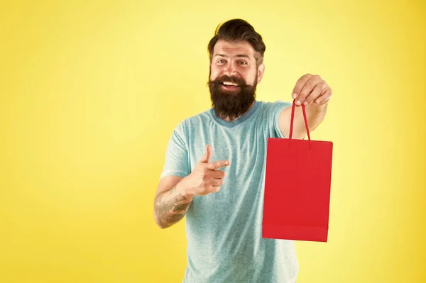 Man with purchase. Impulse purchase. Purchase concept. Male motives for shopping appear to be more utilitarian. Aspects can influence customer decision making behavior. Hipster hold shopping bag — Stock Photo, Image