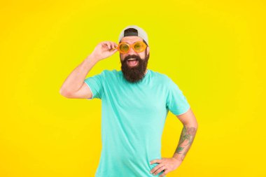 Plaj partim. Sarı arka planda komik gözlüklü adam. Eğlenmene bak. parti aksesuarı. Mutlu adam hipster tarzı gözlük takıyor. Erkek yaz partisi modası. Sakallı ve bıyıklı garip adam.