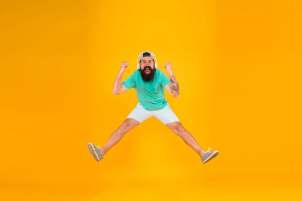 Como uma estrela de rock. O tipo feliz usa auscultadores. festa de férias de verão. Um salto brutal de hipster. a sua canção favorita. dj maduro cheio de energia. sentir liberdade. celebrando o sucesso. homem barbudo ouvir música — Fotografia de Stock