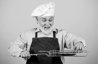Izgara tarifi. Olgun sakallı şef ızgara ızgara ızgarası tutar. Lezzetli ve lezzetli. Izgara yemek. Sağlıklı beslenme şekli. Aile hafta sonu. Barbekü için mutfak aletleri. Piknik ve barbekü konsepti