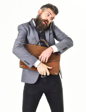 Çantalı meşgul bir adam cep telefonuyla konuşuyor.