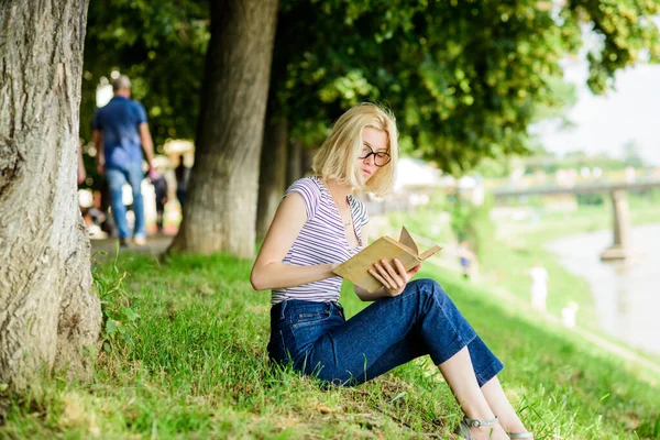 Littérature pour les vacances d'été. Vacances d'été. Étudiant intelligent nerd assis sur l'herbe verte et lire le livre. Fille se détendre au bord de la rivière après la journée de travail. Reste calme et passe temps. Femme rêvant de vacances — Photo