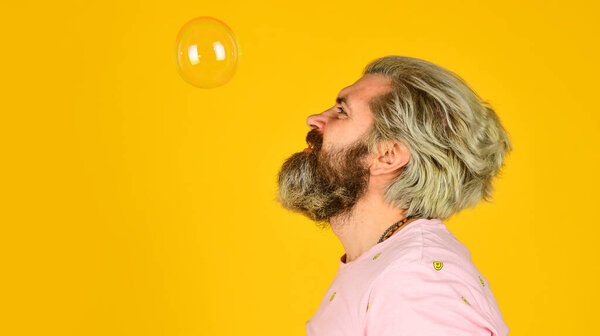 Infantility concept. Happy playful bearded hipster and soap bubbles. Happiness and joy. Good vibes. Blow inflate bubbles. Forever young guy. Positive. Carefree man soap bubbles. Summer vacation