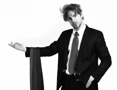 Sakallı, maço, şık takım elbiseli, kravatlı bir adam.